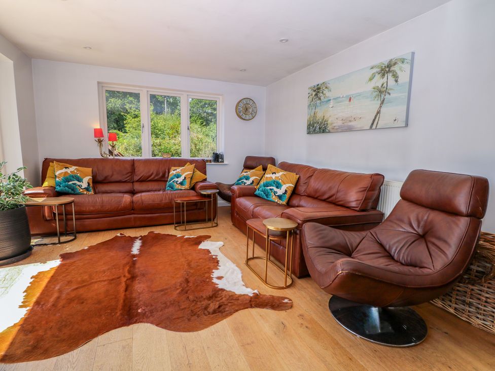 A living room with sofas, an armchair, and a coffee table at Perry Dees in Minstead