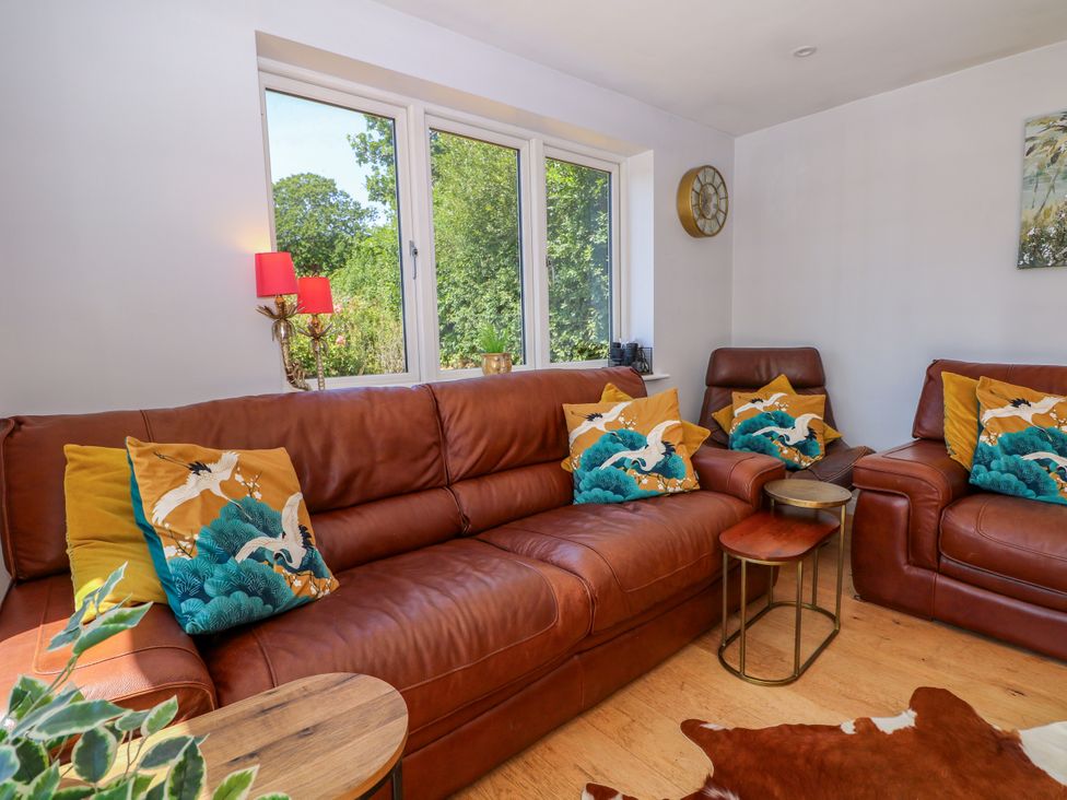 A living room with a brown sofa and cushions at Perry Dees in Minstead