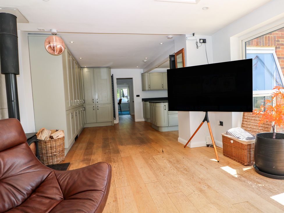A snug with a television and storage cupboards at Perry Dees in Minstead