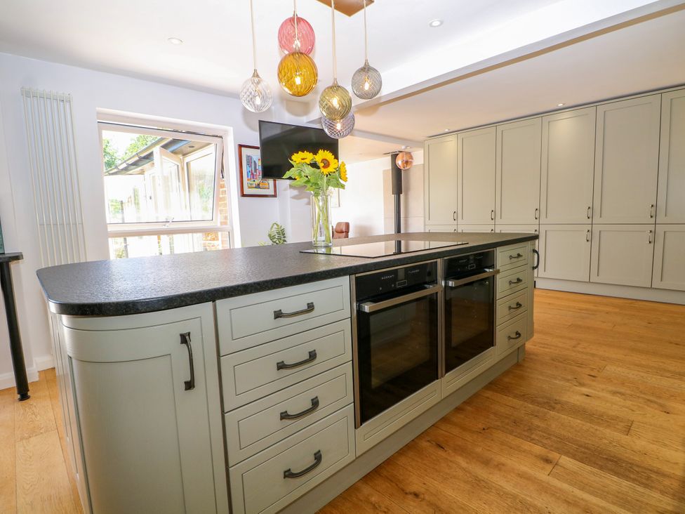 A kitchen with an island and flower vase at Perry Dees in Minstead