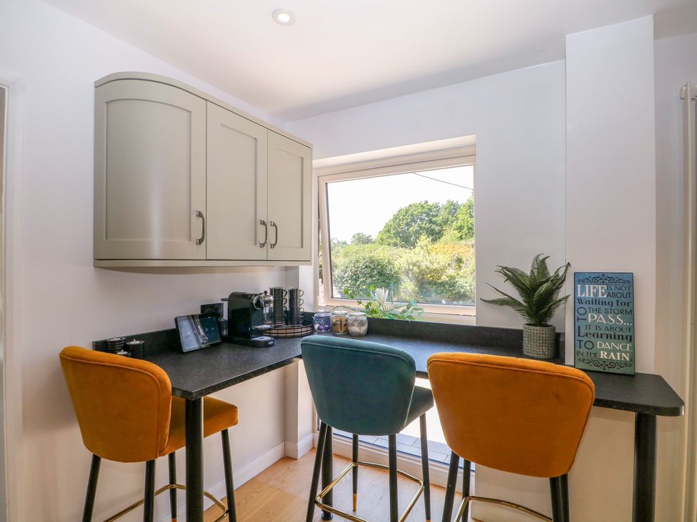A kitchen with bar stools and coffee machine at Perry Dees in Minstead