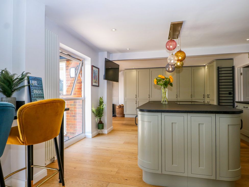 A kitchen with an island and bar stools at Perry Dees in Minstead