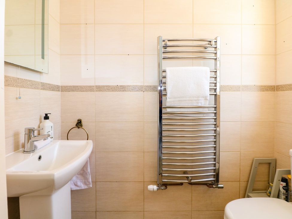 A bathroom with a sink, toilet, towel rack and mirror at Perry Dees in Minstead