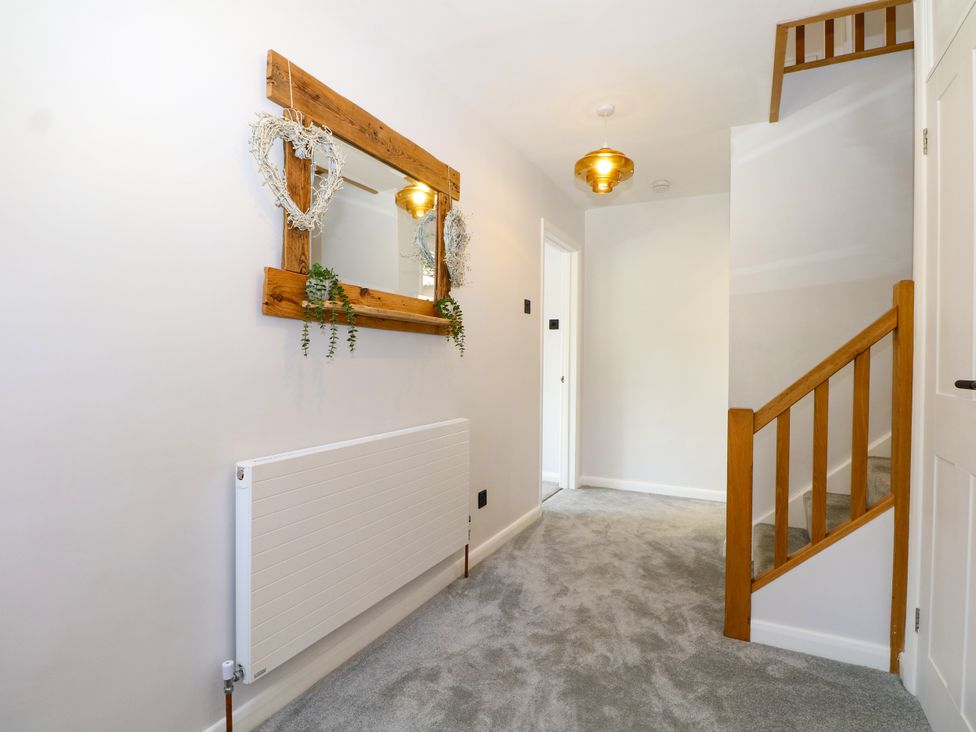 A hallway with a mirror and stairs at Perry Dees in Minstead