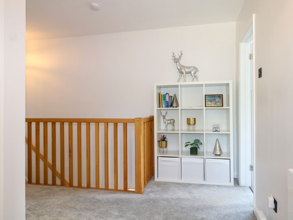 A hallway with a bookshelf and decorative items at Perry Dees in Minstead