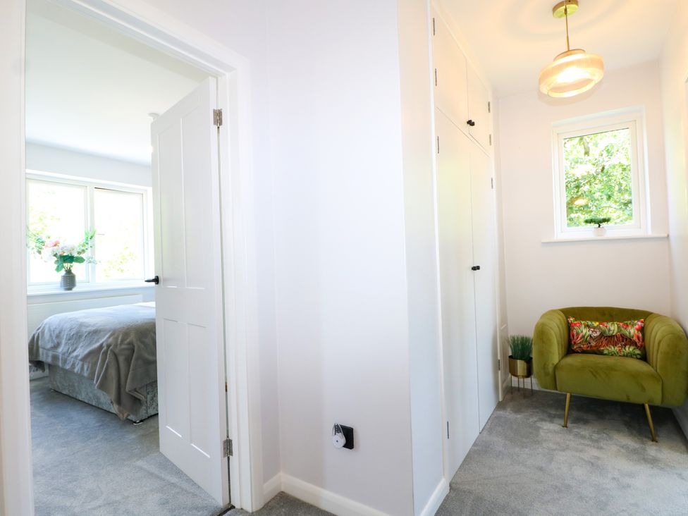 A bedroom with a bed visible through a door at Perry Dees in Minstead