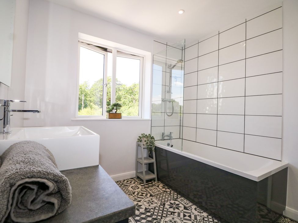 A bathroom with a bathtub and washbasin at Perry Dees in Minstead