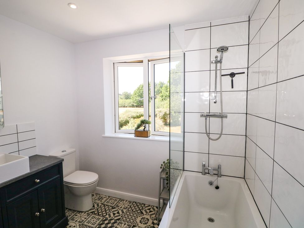 A bathroom with a bathtub, sink, and toilet at Perry Dees in Minstead