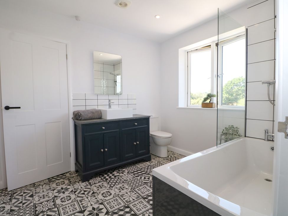 A bathroom with a bath tub and sink at Perry Dees in Minstead