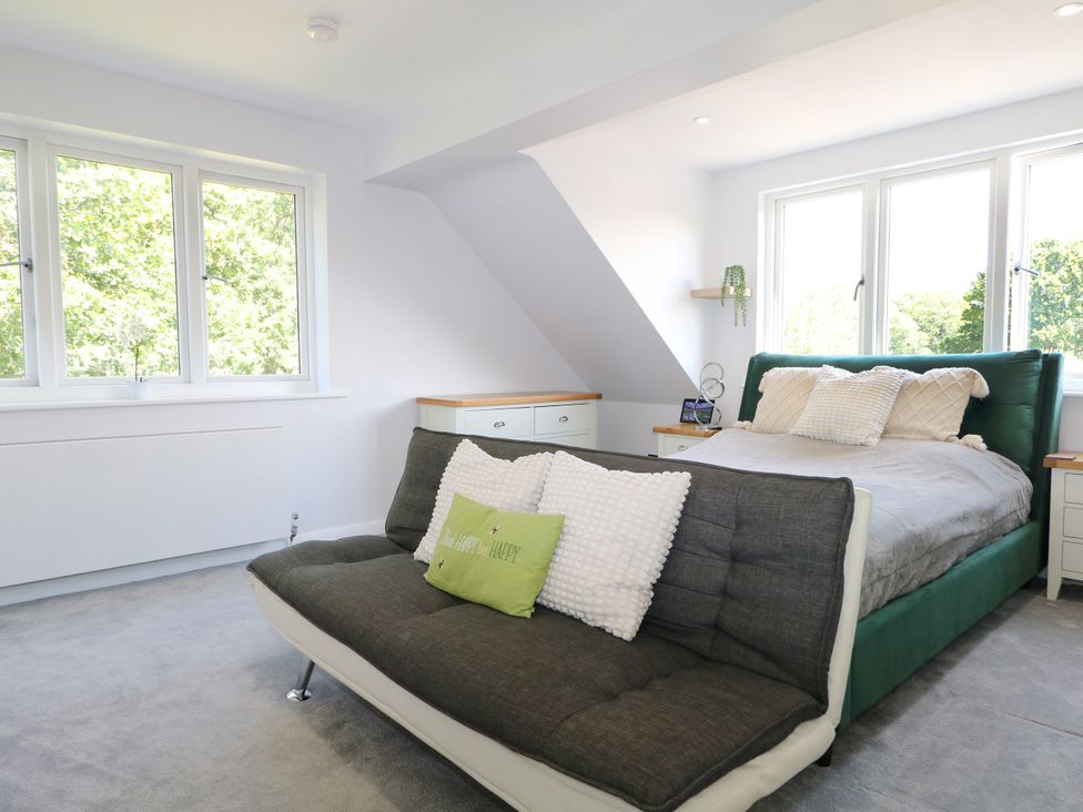 A bedroom with a bed and a sofa at Perry Dees in Minstead