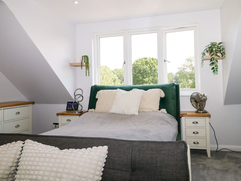 A bedroom with a bed and windows at Perry Dees in Minstead