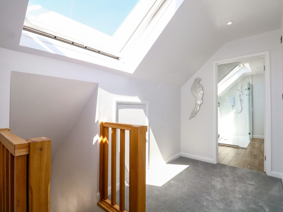 A landing area with a skylight and a shower door at Perry Dees in Minstead