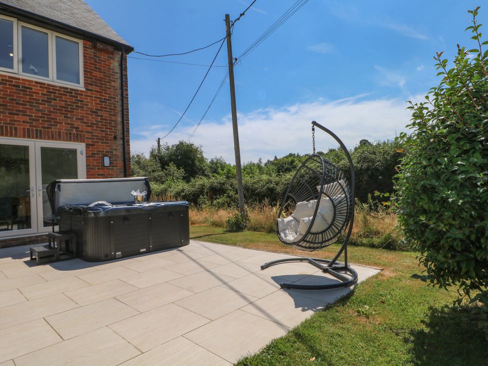 An outdoor area with a hot tub and hanging chair at Perry Dees in Minstead