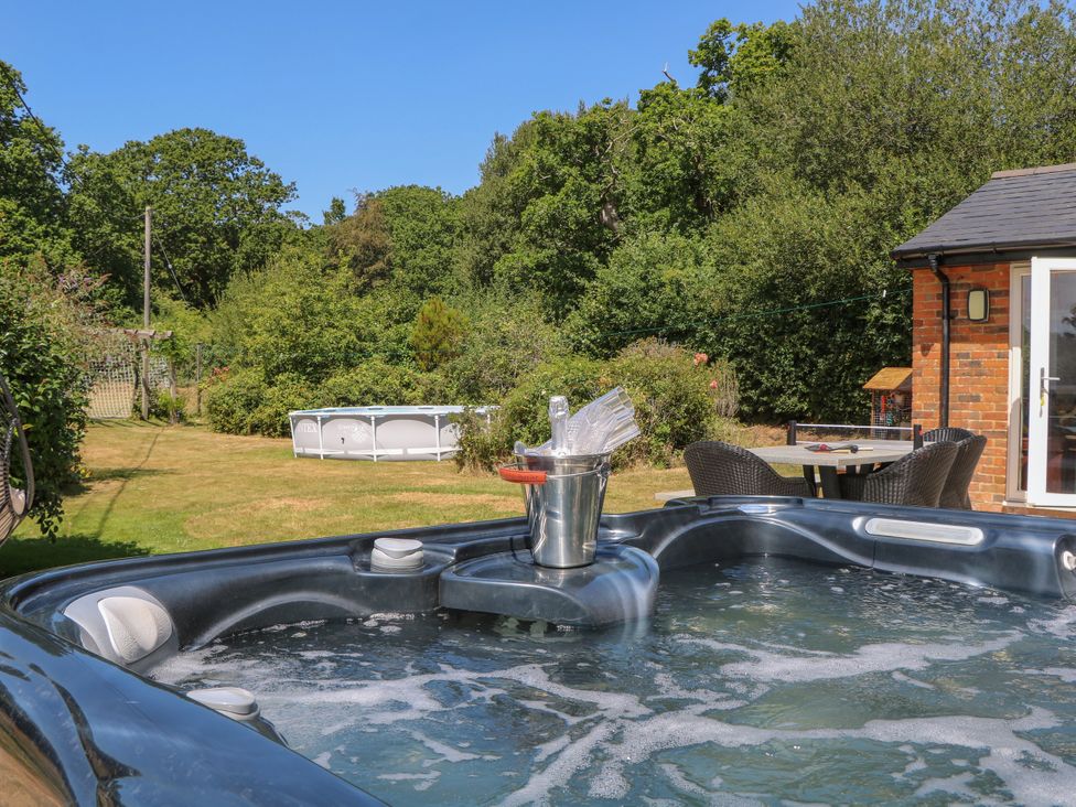 A hot tub with an ice bucket in a garden at Perry Dees in Minstead