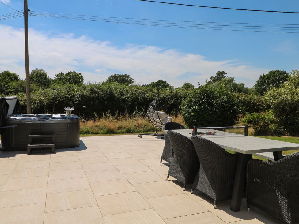 An outdoor space with a hot tub and dining table at Perry Dees in Minstead