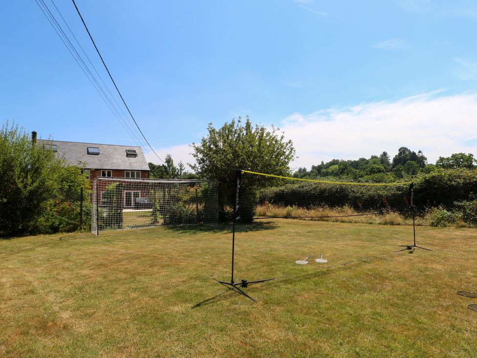 An outdoor area featuring a volleyball net and a house in the background at Perry Dees in Minstead