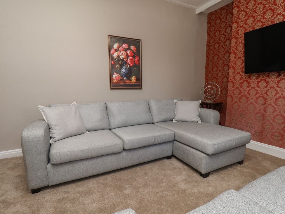 A living room with a gray sofa and a painting at Lansdowne Grange in Bridlington