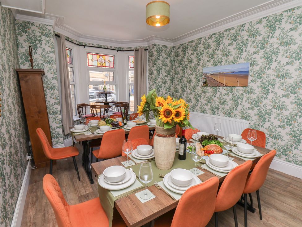 A dining room with a large table set for a meal at Lansdowne Grange in Bridlington