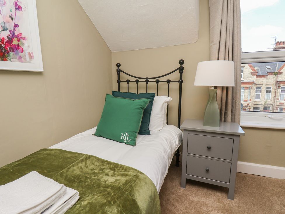 A bedroom with a single bed and nightstand at Lansdowne Grange in Bridlington