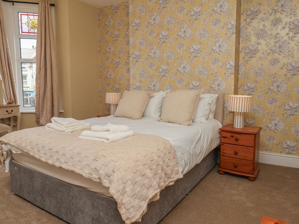 A bedroom with a bed and a wooden table at Lansdowne Grange in Bridlington