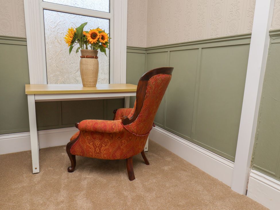 A room with a table and flowers in a vase at Lansdowne Grange in Bridlington
