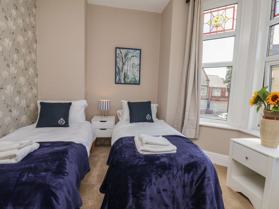 A bedroom with twin beds and a window at Lansdowne Grange in Bridlington