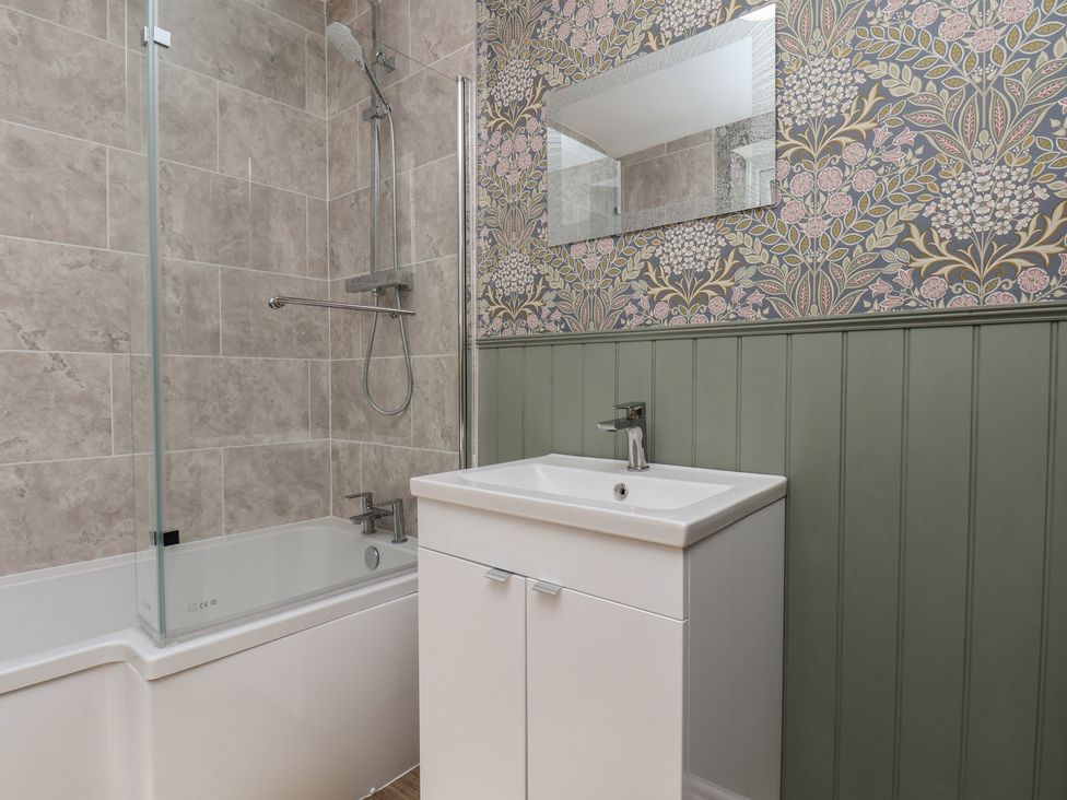 A bathroom with a bathtub and sink at Lansdowne Grange in Bridlington