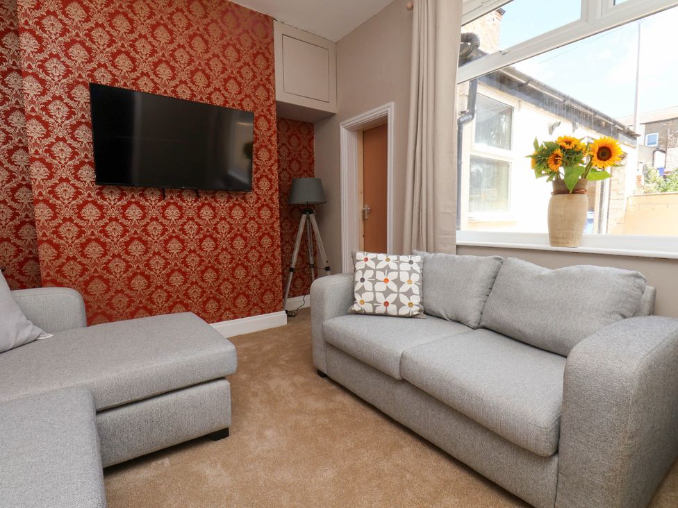 A living room with a sofa and tv at Lansdowne Grange in Bridlington