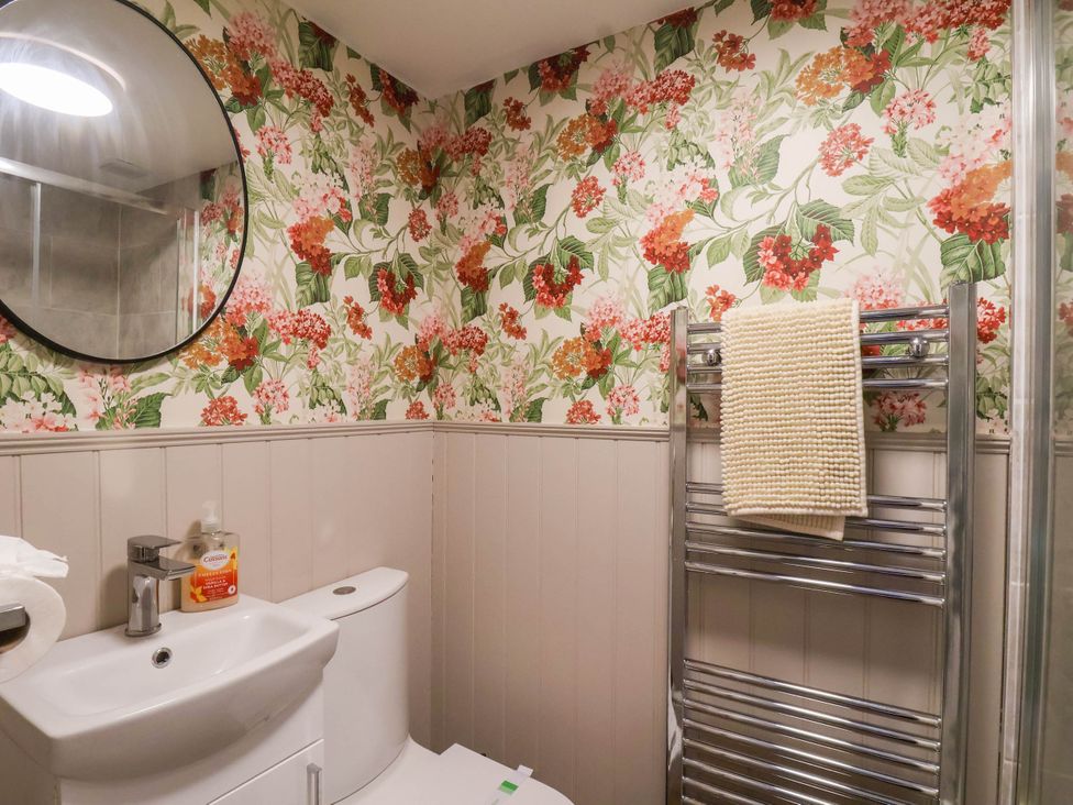 A bathroom with a toilet, sink, and towel rail at Lansdowne Grange in Bridlington