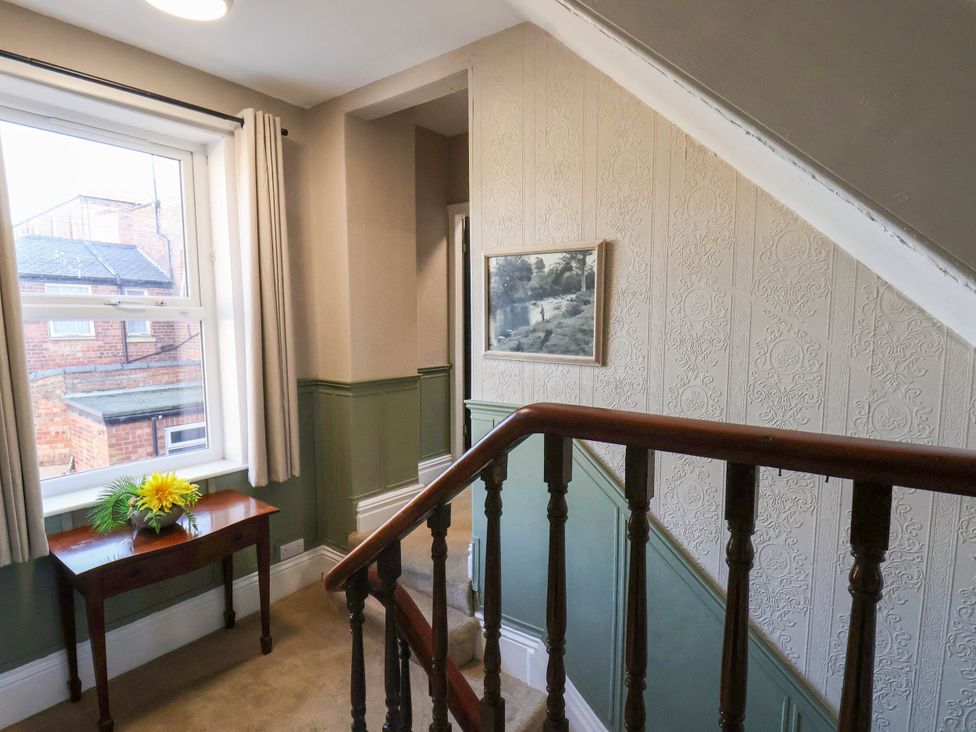 A staircase with a table and window at Lansdowne Grange in Bridlington
