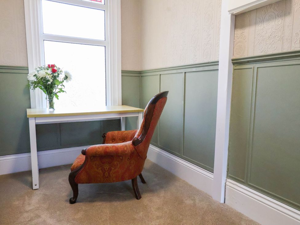 A study with a chair and table in front of a window at Lansdowne Grange in Bridlington