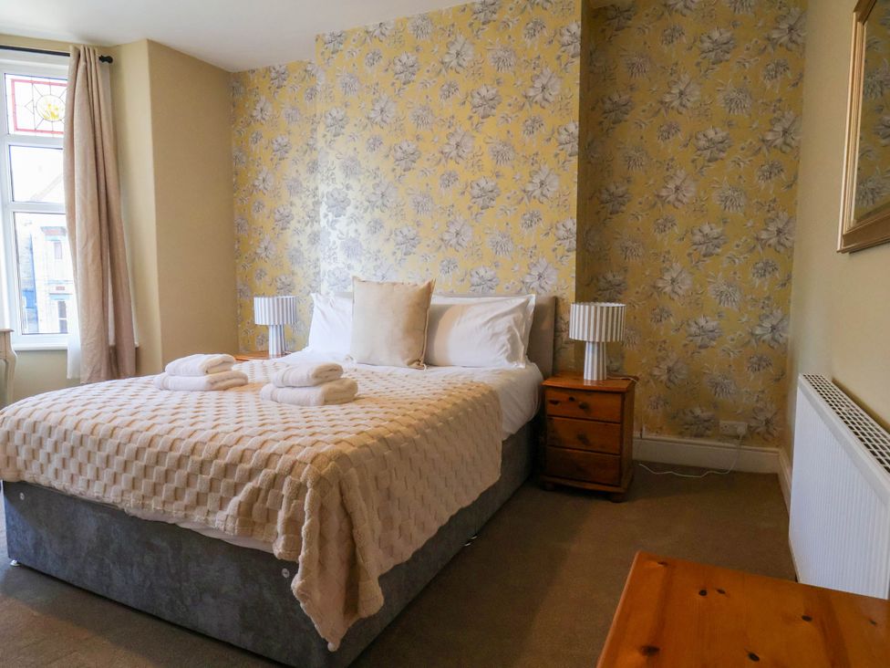 A bedroom with a bed and bedside table at Lansdowne Grange in Bridlington