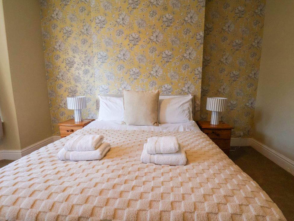 A bedroom with a bed and lamps at Lansdowne Grange in Bridlington