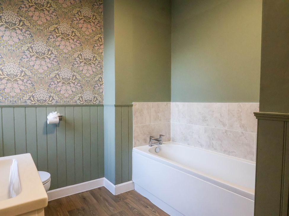 A bathroom with a bathtub and toilet at Lansdowne Grange in Bridlington
