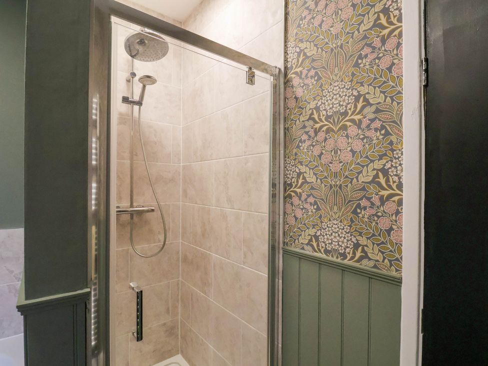 A shower with a glass door in a bathroom at Lansdowne Grange in Bridlington