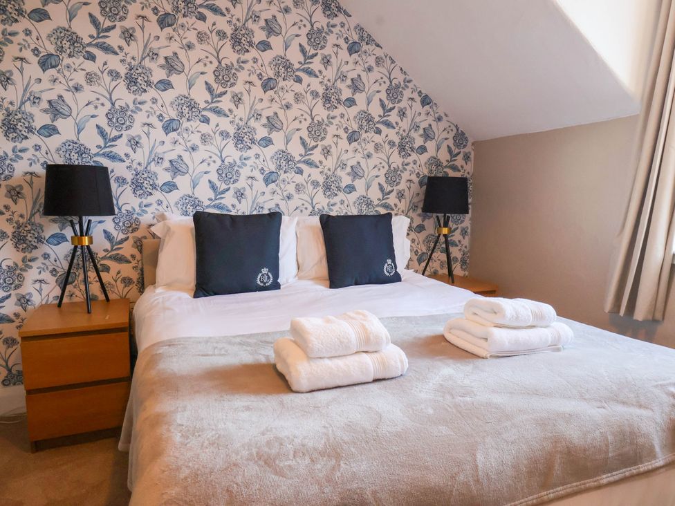 A bedroom with a bed, pillows, lamp, and towels at Lansdowne Grange in Bridlington