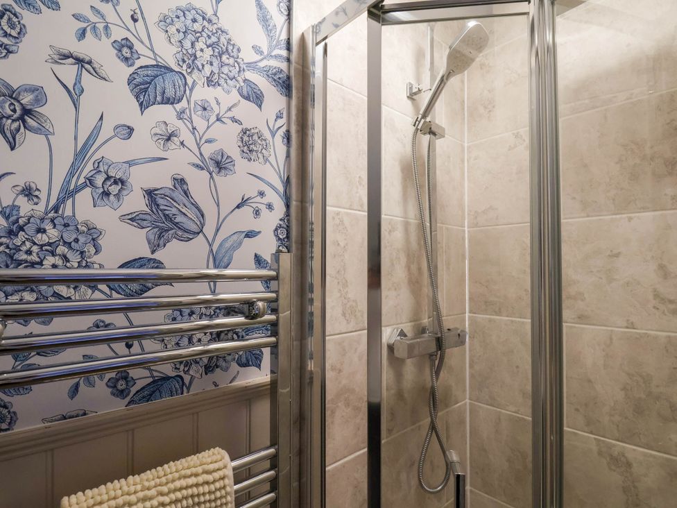 A bathroom with a shower and towel rail at Lansdowne Grange in Bridlington