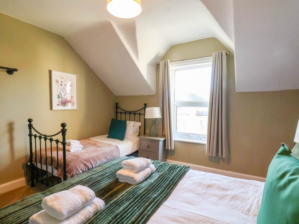 A bedroom with two beds and a window at Lansdowne Grange in Bridlington