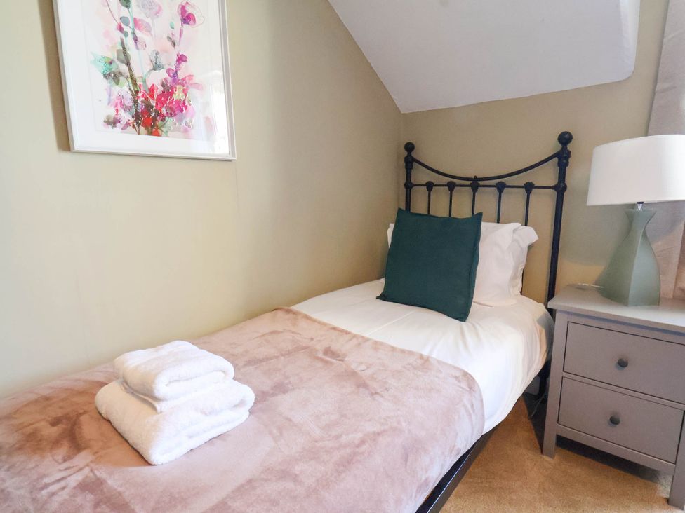 A bedroom with a bed, towels and a lamp at Lansdowne Grange in Bridlington