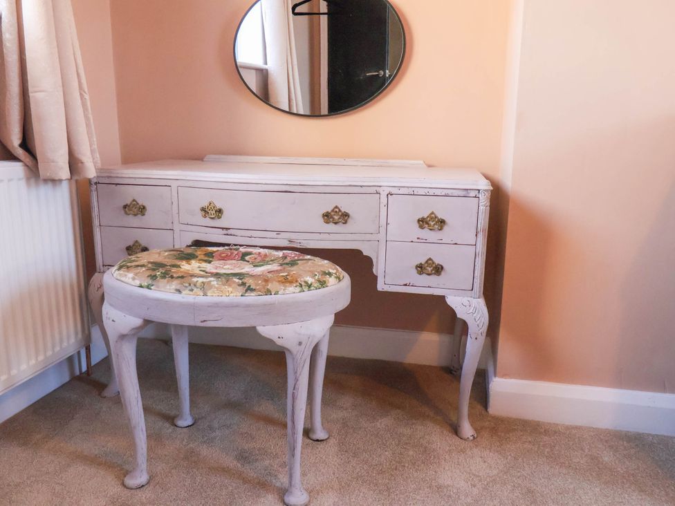 A vanity table with a mirror and a stool at Lansdowne Grange in Bridlington