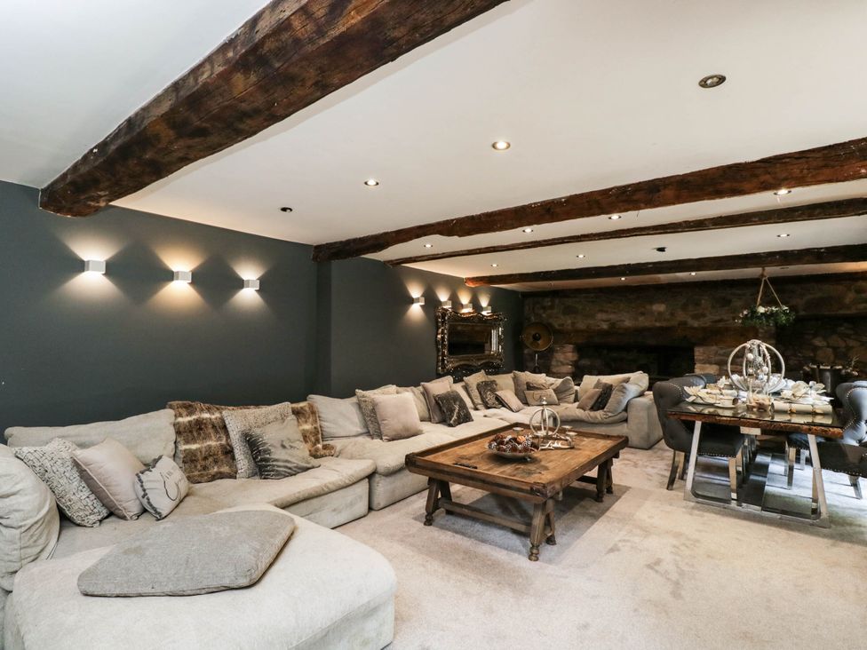 A living room with a sofa and dining table at Llanfarach Farmhouse near Pontyclun