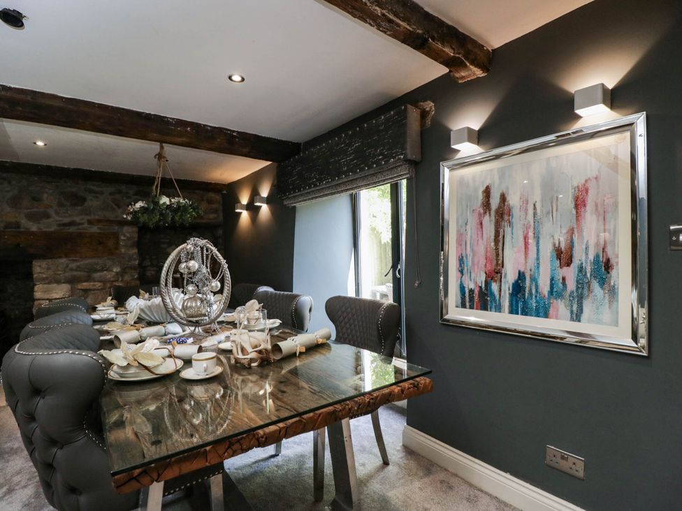 A dining room with a table set for dinner at Llanfarach Farmhouse near Pontyclun