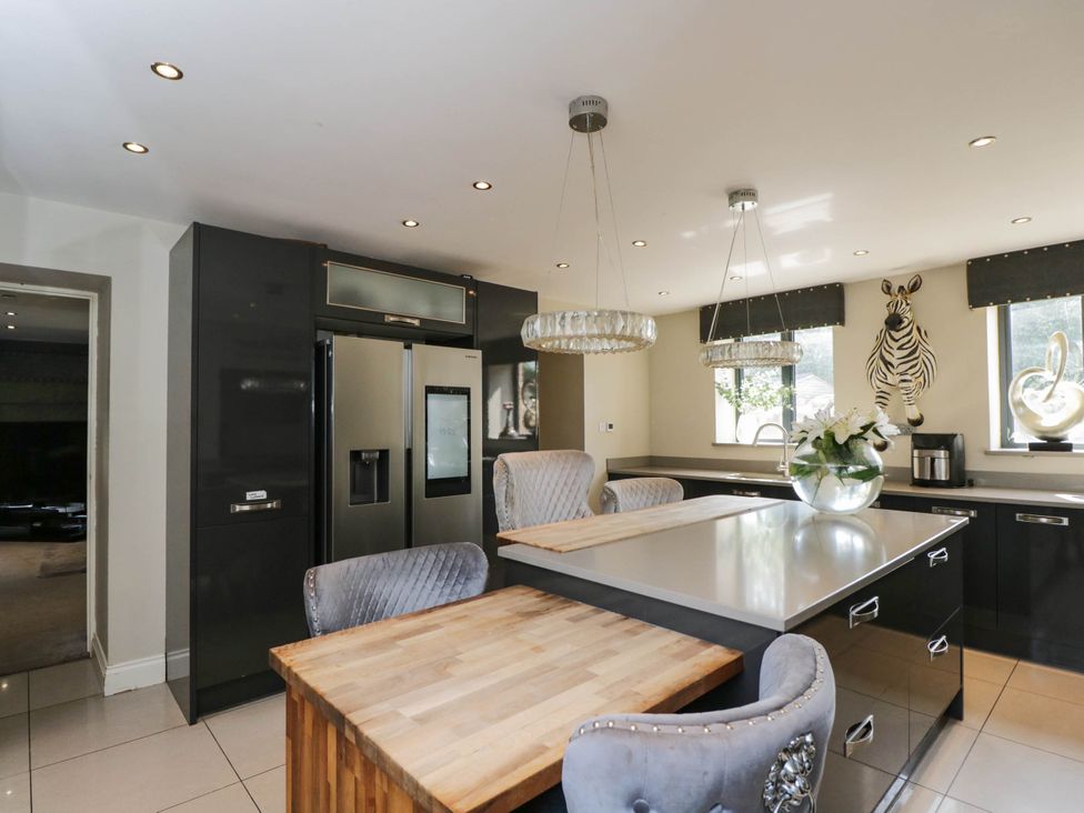A kitchen with a refrigerator and kitchen island at Llanfarach Farmhouse near Pontyclun