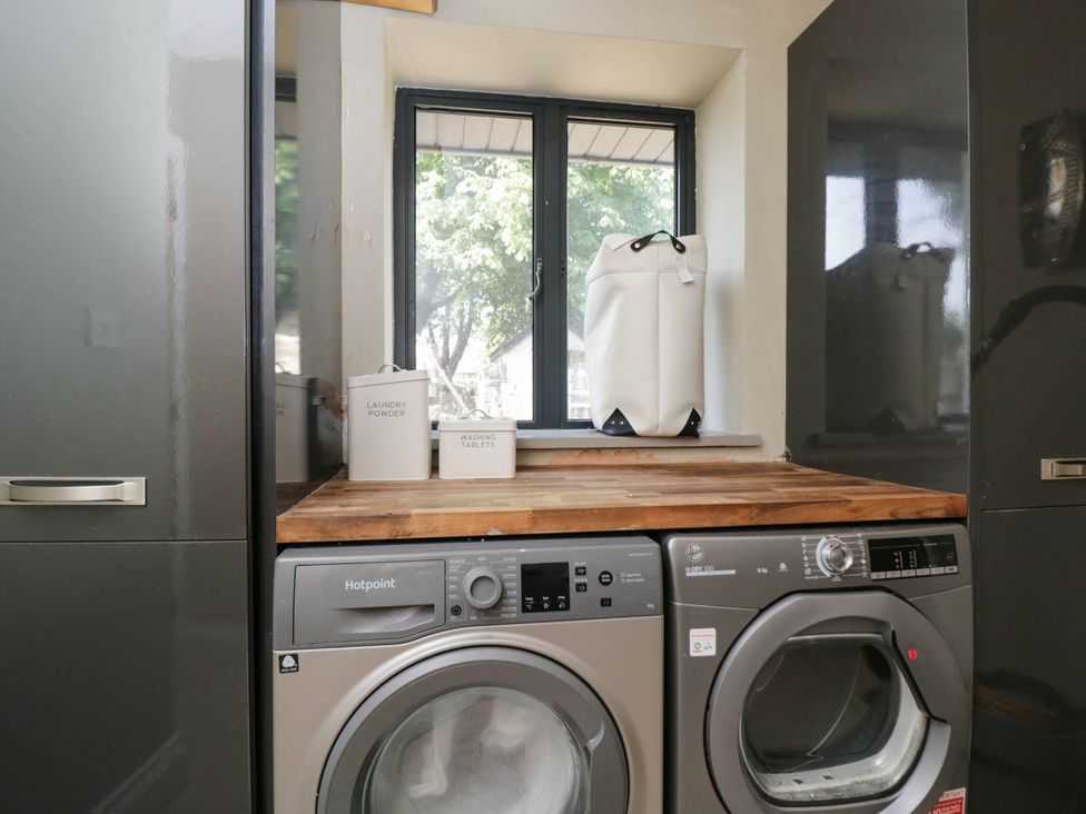 A laundry room with a washing machine and dryer at Llanfarach Farmhouse near Pontyclun