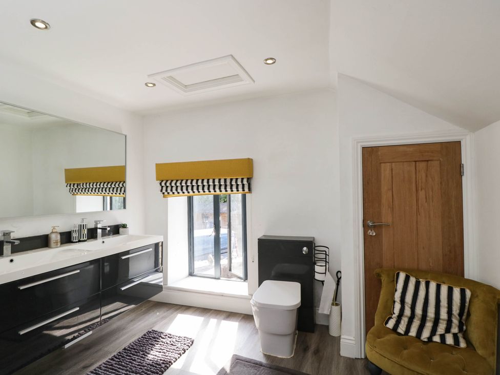 A bathroom with a sink and mirror at Llanfarach Farmhouse near Pontyclun