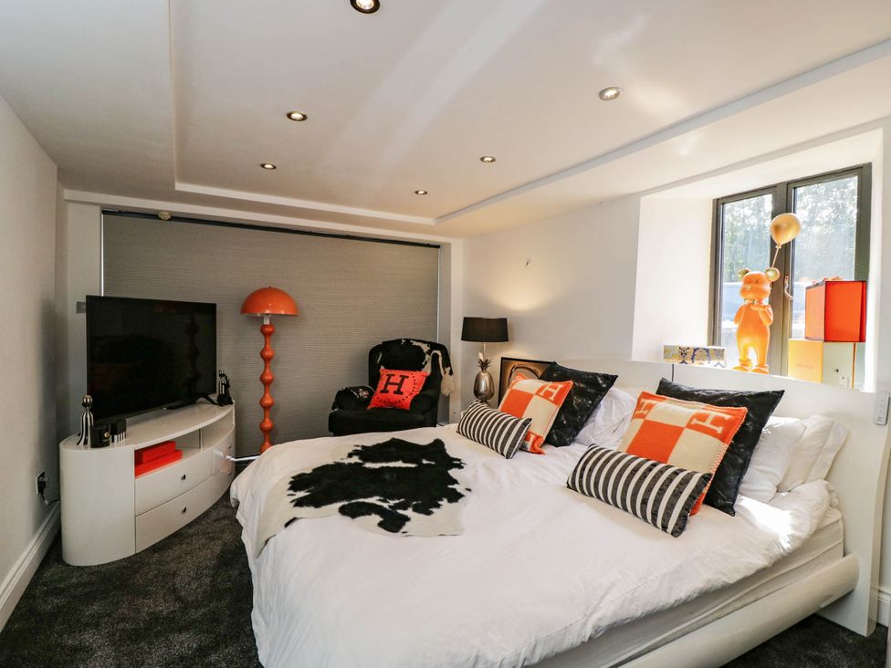A bedroom with a bed and television at Llanfarach Farmhouse near Pontyclun