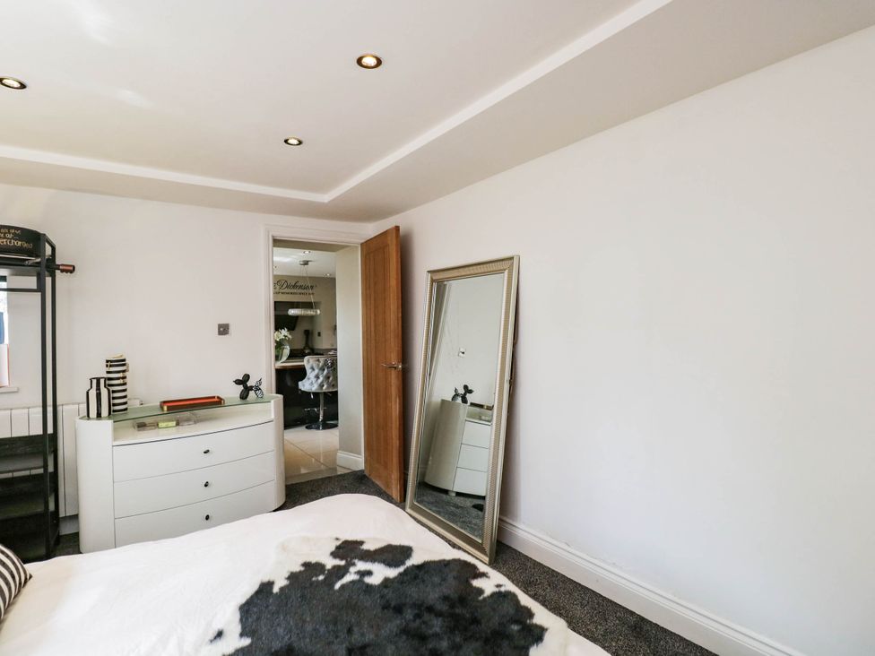 A bedroom with a bed and a mirror at Llanfarach Farmhouse near Pontyclun