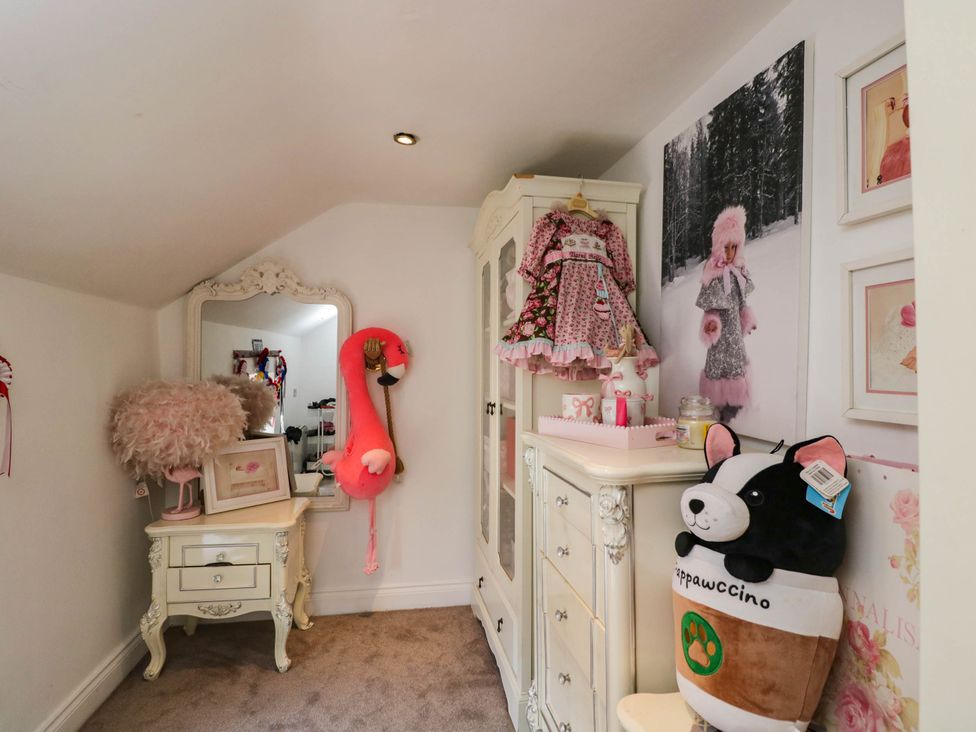 A bedroom with furniture and decor at Llanfarach Farmhouse near Pontyclun