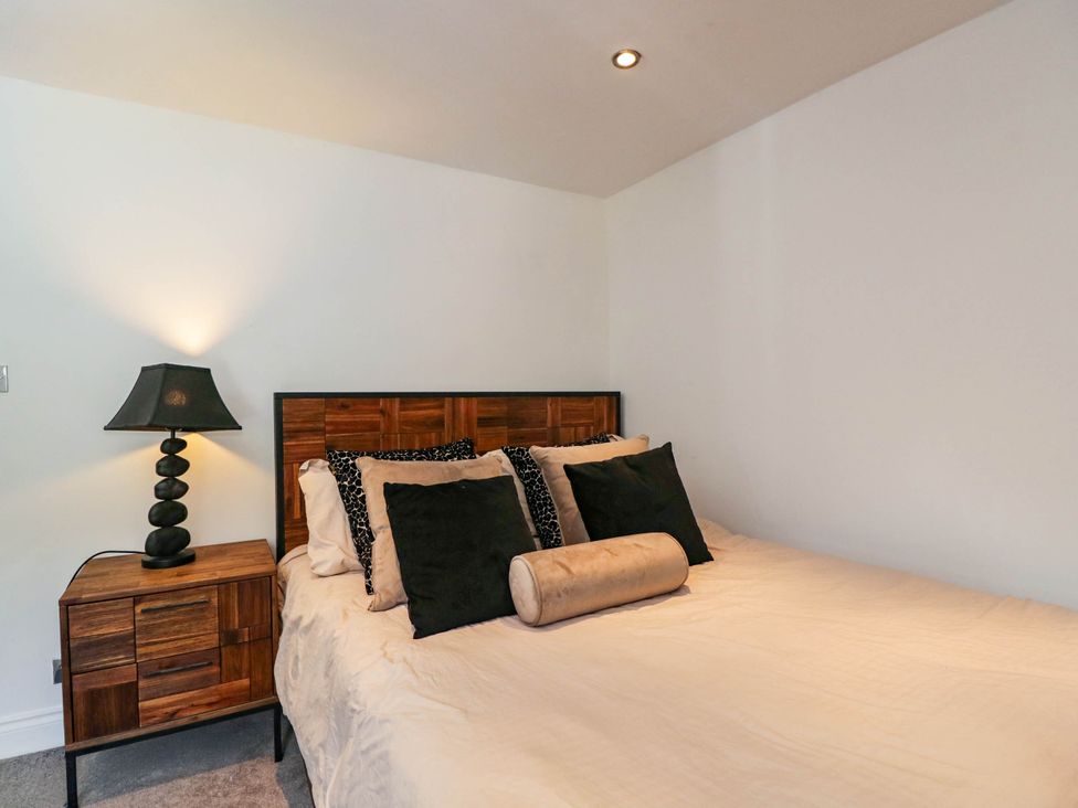 A bedroom with a bed and nightstand at Llanfarach Farmhouse near Pontyclun