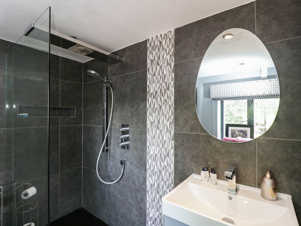 A bathroom with a shower and sink at Llanfarach Farmhouse near Pontyclun